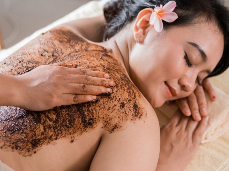 woman in spa salon having spa therapy coffee scrub